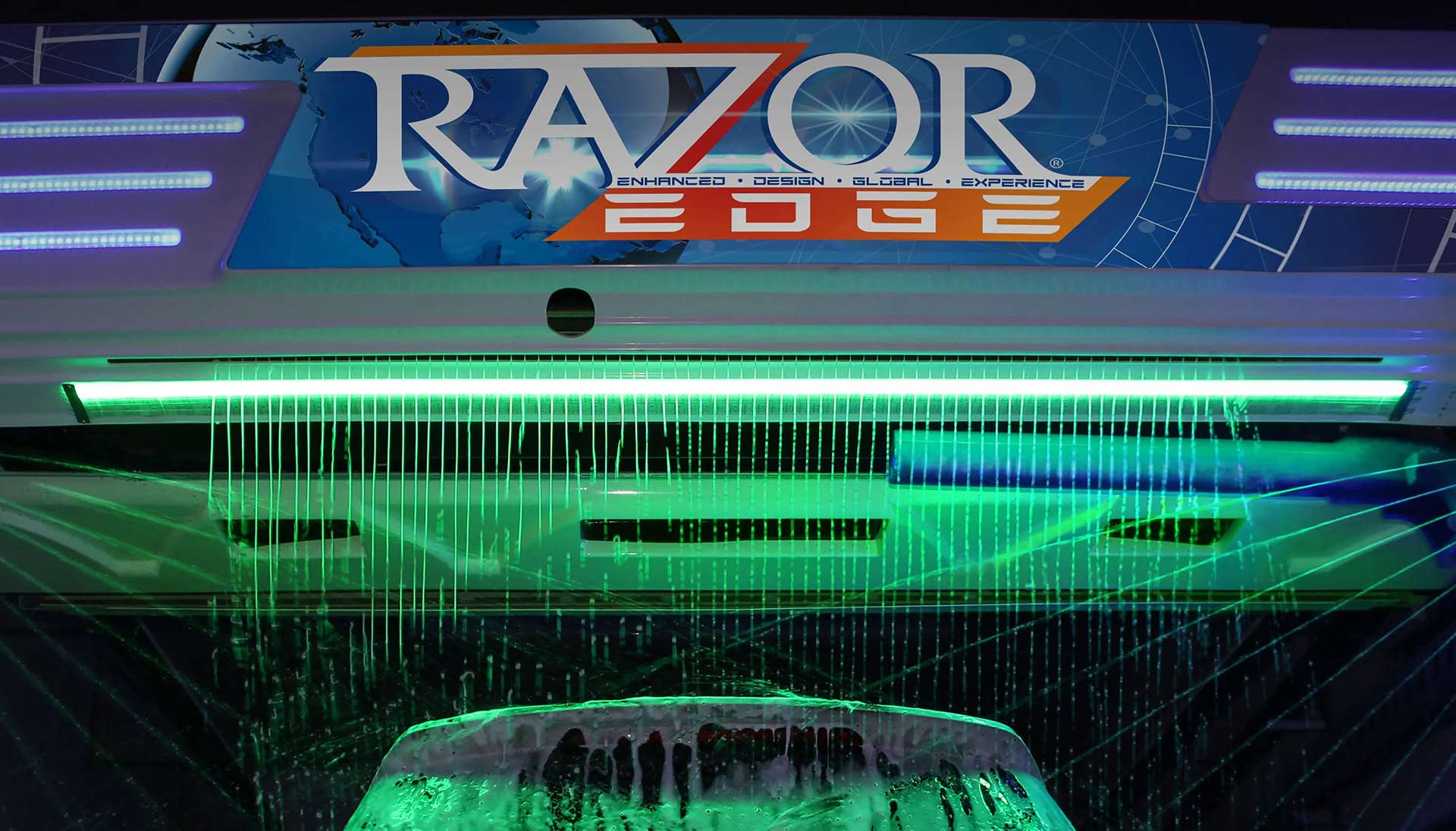 A car going through a touchless car wash, illuminated by green LED lights, with suds cascading down over the vehicle, highlighting the Razor Edge wash process.